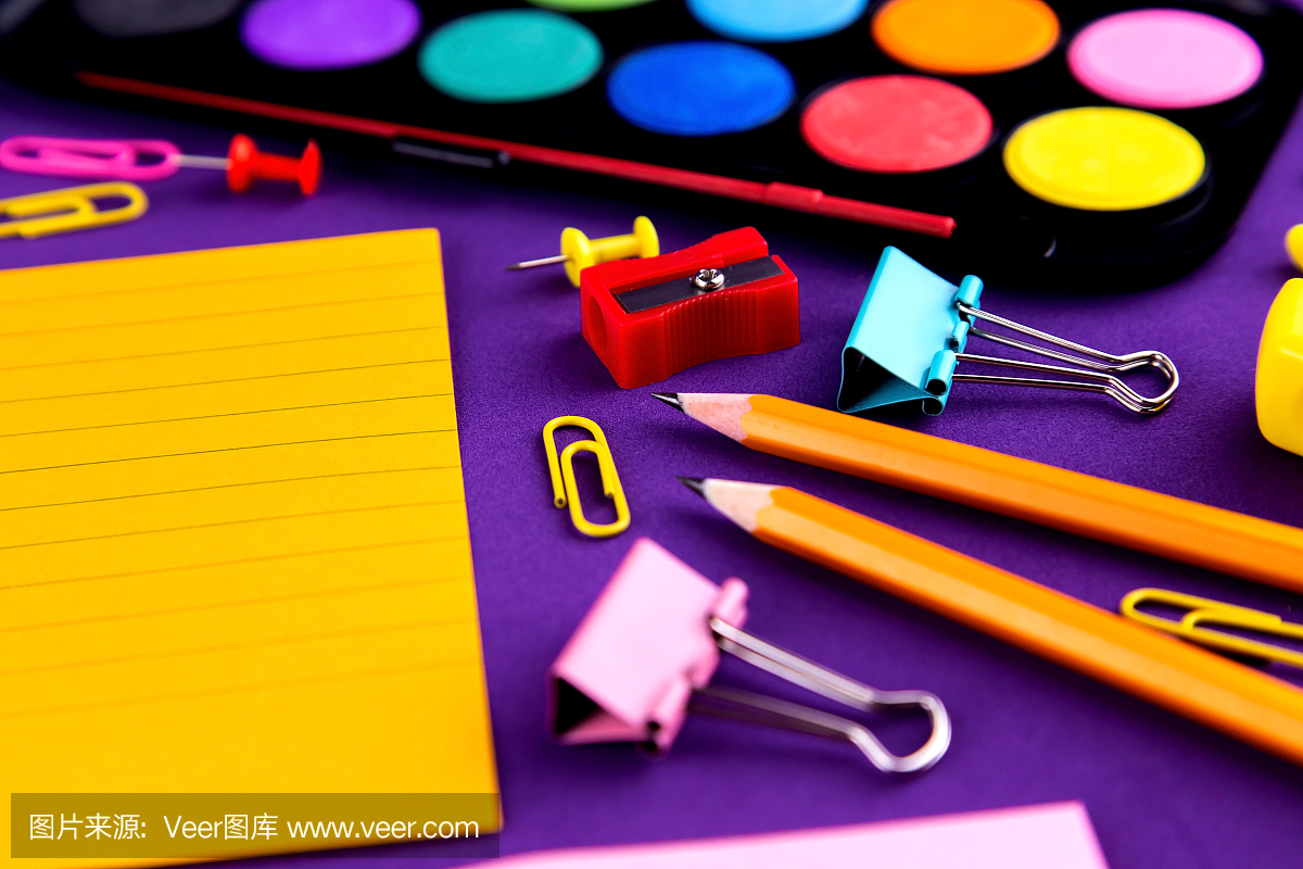 学校办公用品文具在紫色的背景桌子上有复印空间。返校理念