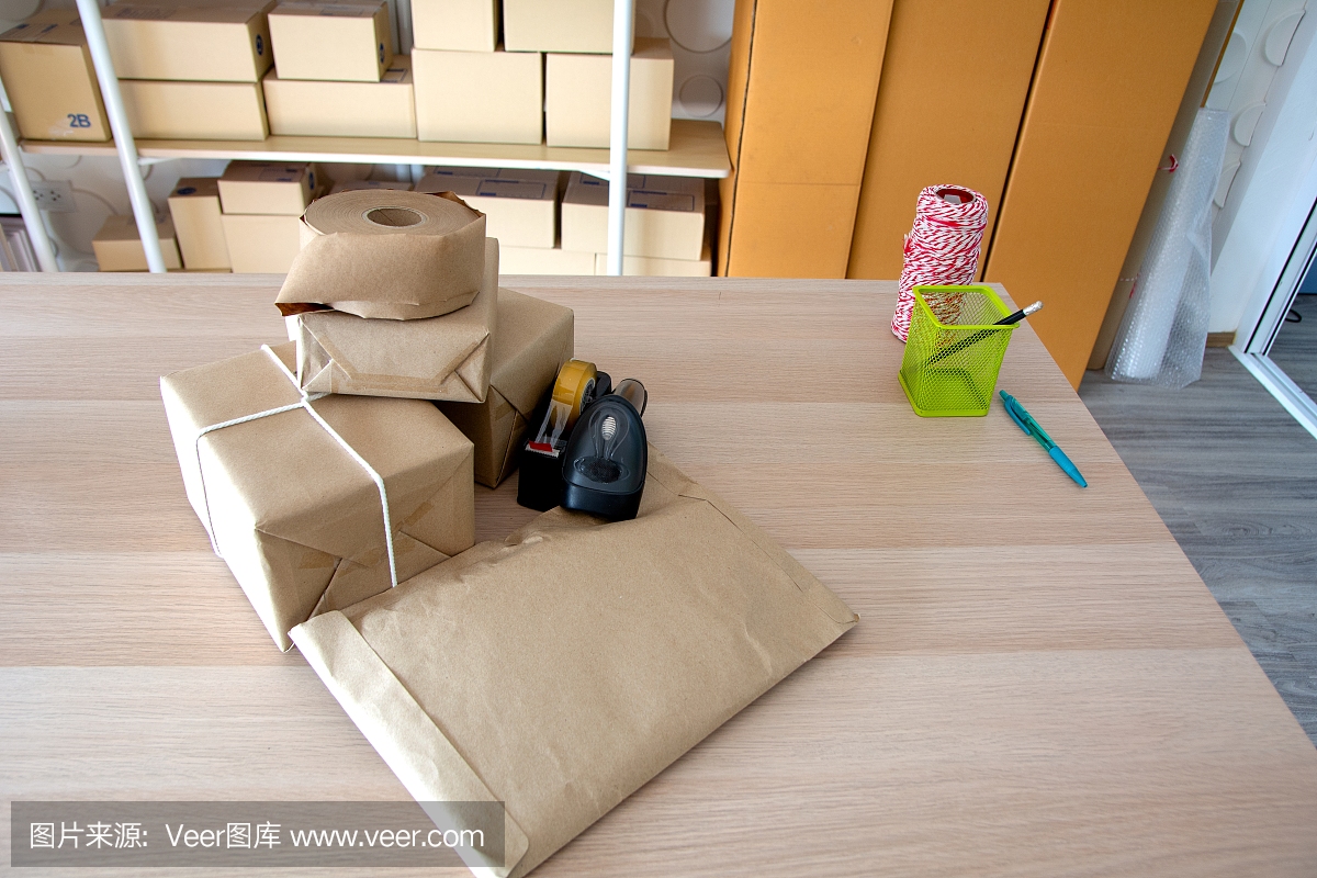 创业小企业主工作场所的包装配件,用于网上销售的纸板箱。邮包箱,条形码阅读器,用于网上销售。运输的概念